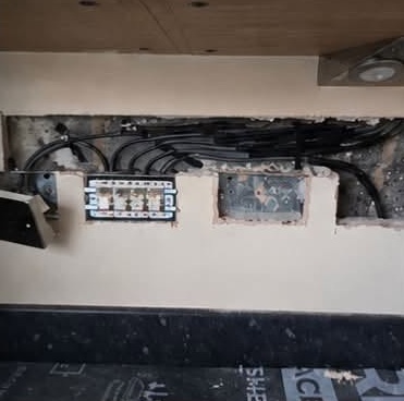 Kitchen wall above worktop cut out with exposed cables