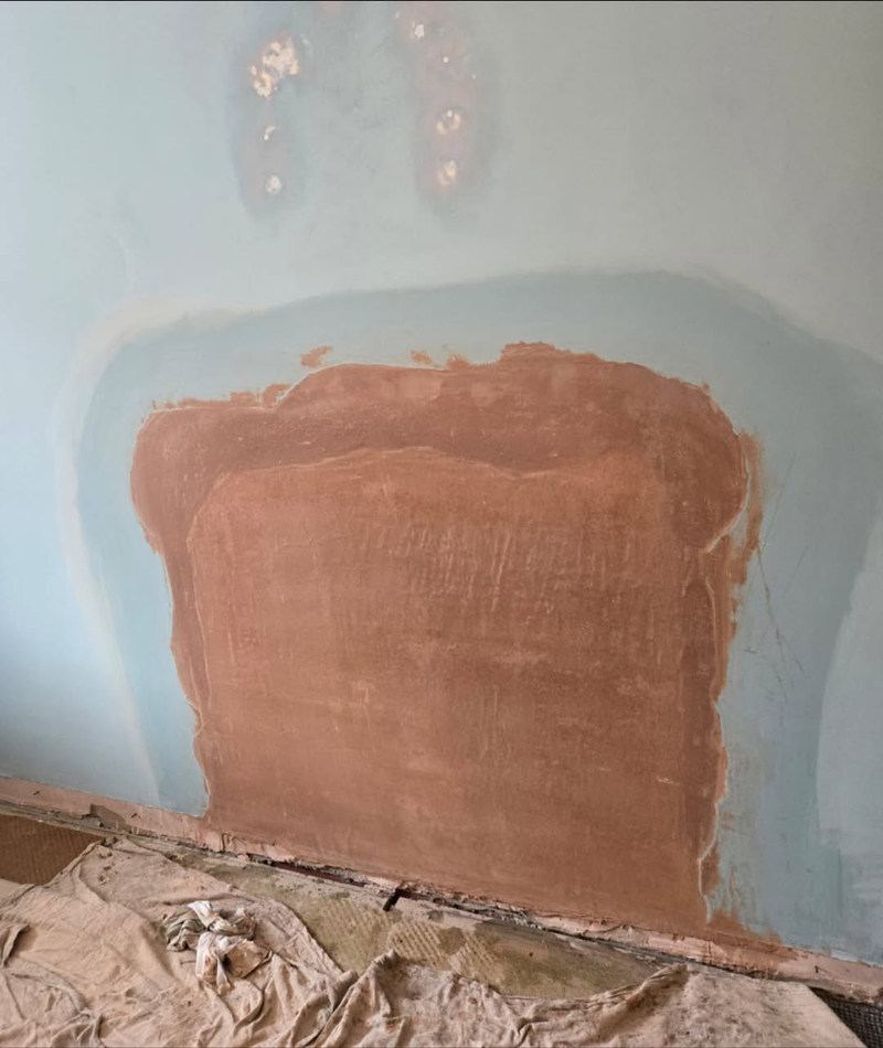 Patch repair in backing coat on a blue wall