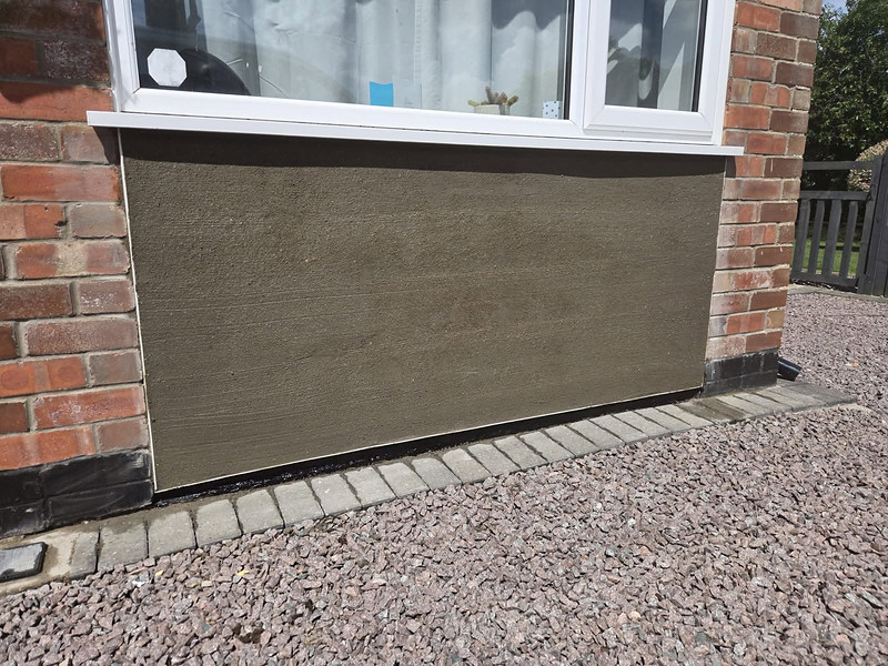 External render panel under a window on a brick house