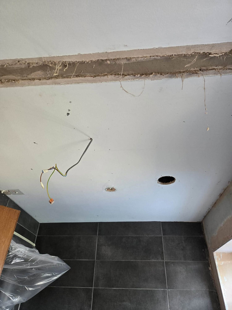 Skimmed ceiling with a timber beam above a tiled floor