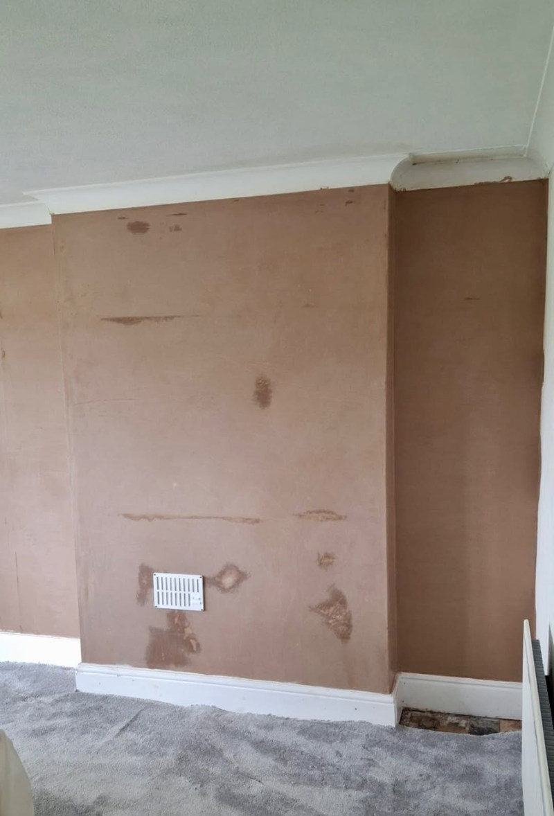 Freshly skimmed chimney-breast wall under coving