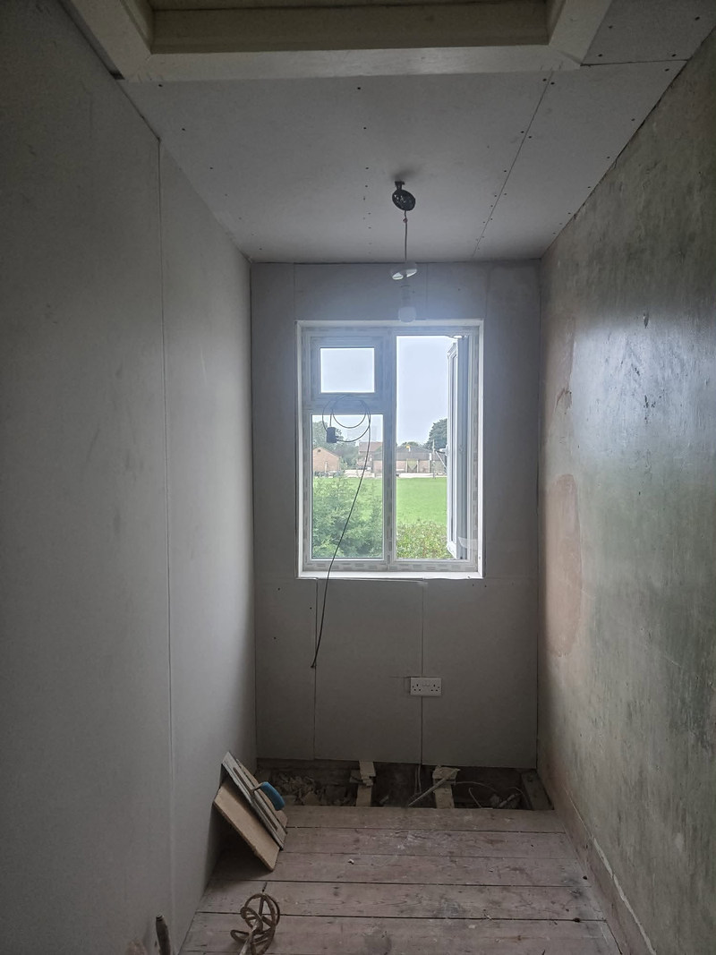 Narrow room with fresh skim on walls and ceiling